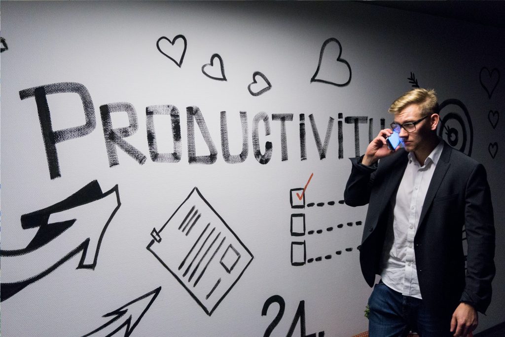 productivity sign with a male on his phone in an office